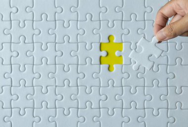 Kadınların elinde yapboz parçaları, yapboz beyaz renk, yapboz parçaları ızgara, Başarı mozaik çözüm şablonu, yazı için sarı arkaplan fotokopi uzayı üzerinde yatay, Üst görünüm