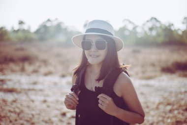 Güzel Asyalı kadın portresi mutlu ve doğaya gülümsüyor gün batımında, rahatla ve boş zaman