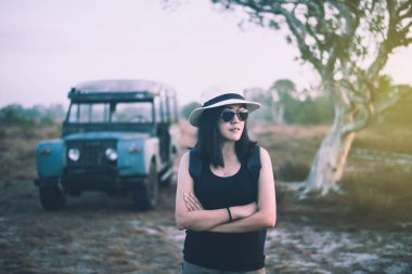 Hipster gezgin Asyalı kadın gün batımında ayakta duruyor ve bir şeye bakıyor, zamanı rahatlatıyor.