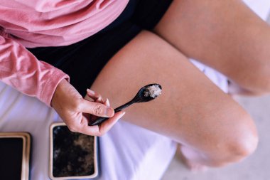 Otelde Himalaya tuzunu ahşap kaşıkta tutan kadın, güzellik ve cilt konsepti.