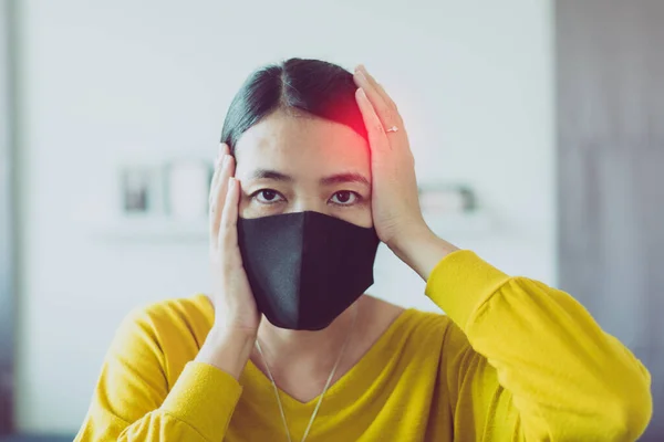 Maske kullanan Asyalı kadın Başbakan 2.5 'u koruyor çünkü evdeki kirlilik, genç bayanın baş ağrısı ve burun alerjisi var.