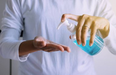 Hijyen koronavirüsü koruma konsepti, kadın elleri pompa şişesinde dezenfektan jeli kullanıyor.