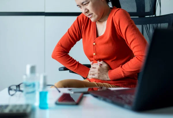 亚洲妇女在家工作时肚子痛 女性肚子痛 经期抽筋 双手捏紧 — 图库照片