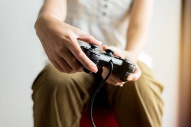 Ellerini kapat, kadın evde video oyunu oynuyor, kadınlar joystick tutuyor.