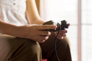 Ellerini kapat, kadın evde video oyunu oynuyor, kadınlar joystick tutuyor.