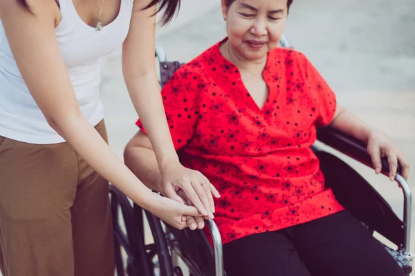 妇女手牵着亚洲人成熟的手坐在轮椅上 老年保险概念 — 图库照片