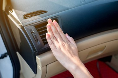 Elli kadının modern arabadaki klimadan gelen soğuk akışı kontrol etmesi, arabadaki soğutma sistemi, otomatik klima.