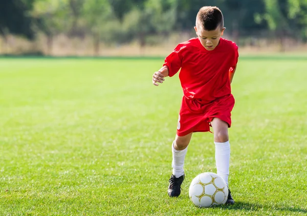 Poika potkii jalkapalloa — kuvapankkivalokuva