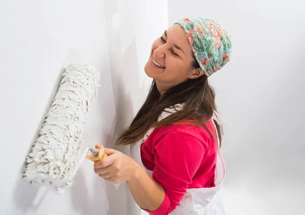 Счастливая молодая женщина, рисующая стену — стоковое фото