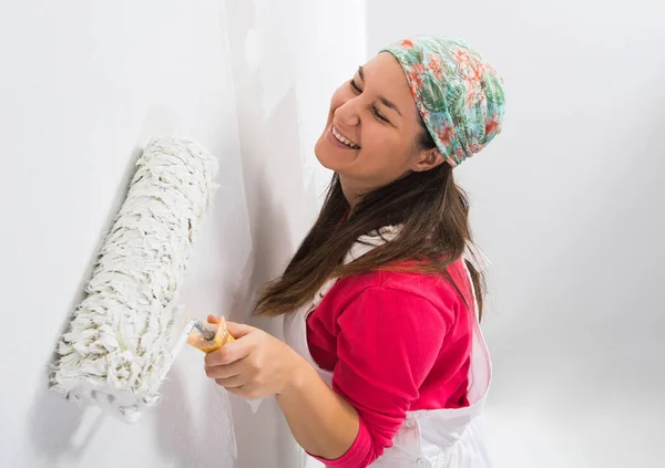 Mujer joven feliz pintando una pared —  Fotos de Stock