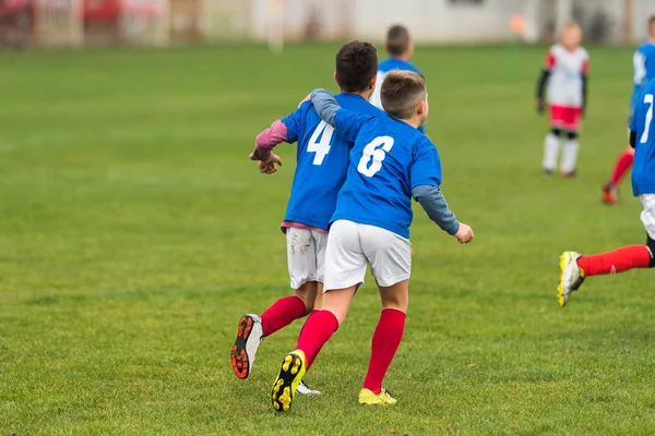 Jóvenes chicos de fútbol abrazándose durante el partido de fútbol — Foto de Stock