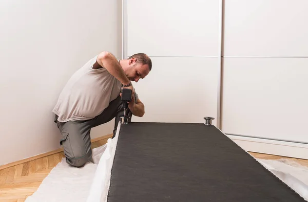 Furniture maker sets bed — Stock Photo, Image