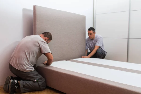 Furniture maker sets bed — Stock Photo, Image