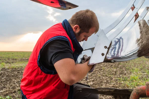 Mechanic fixing plow on the tractor — Stock Photo, Image