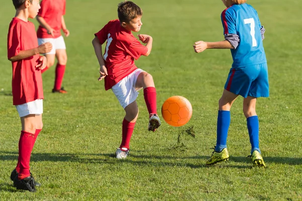 Rapaz chutando bola de futebol — Fotografia de Stock