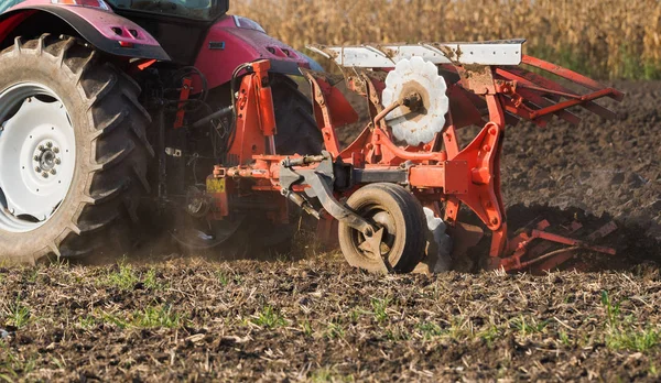 Traktor mit einem Pflug arbeitet — Stockfoto