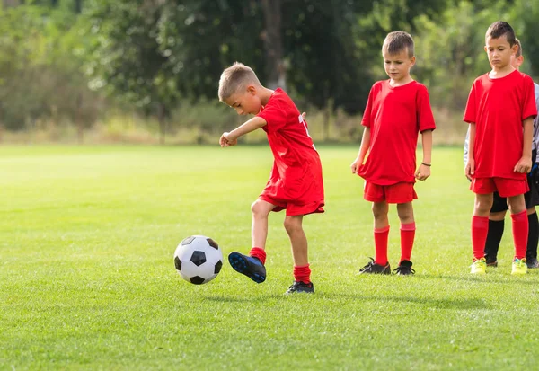 Pojken sparkar fotboll på utbildning — Stockfoto