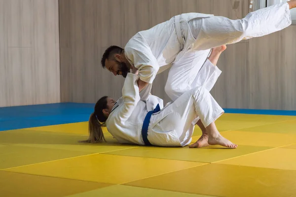 Kvinnan och mannen judo fighters i sporthall — Stockfoto