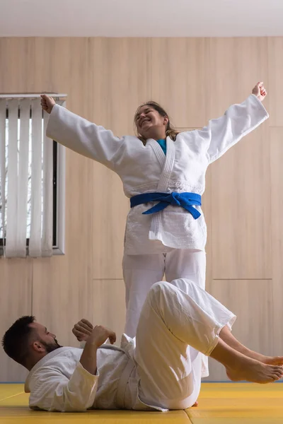 Kvinnan och mannen judo fighters i sporthall — Stockfoto