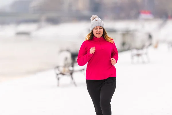 Mädchen trägt Sportbekleidung und läuft im Winter auf Schnee — Stockfoto