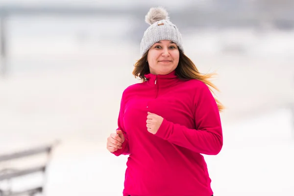 Mädchen trägt Sportbekleidung und läuft im Winter auf Schnee — Stockfoto