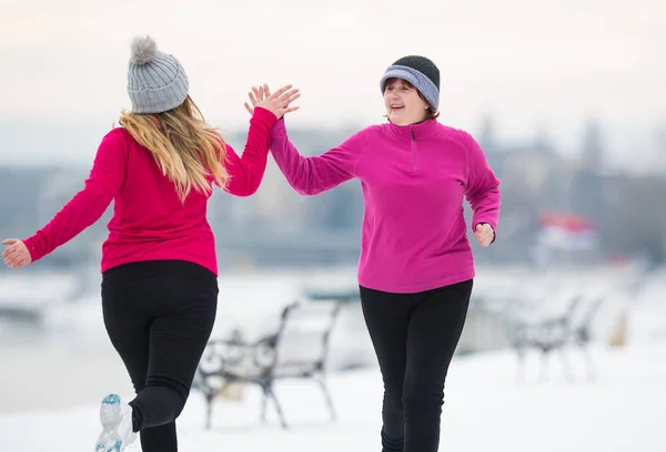 Мать и дочь в спортивной одежде и бегают по снегу дюрин — стоковое фото