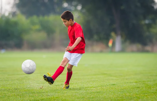 Chlapec kope fotbalový míč — Stock fotografie