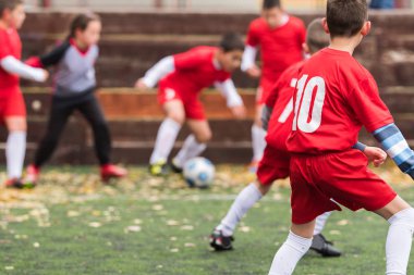  Spor sahasında futbol topu tekmeleme çocuklar