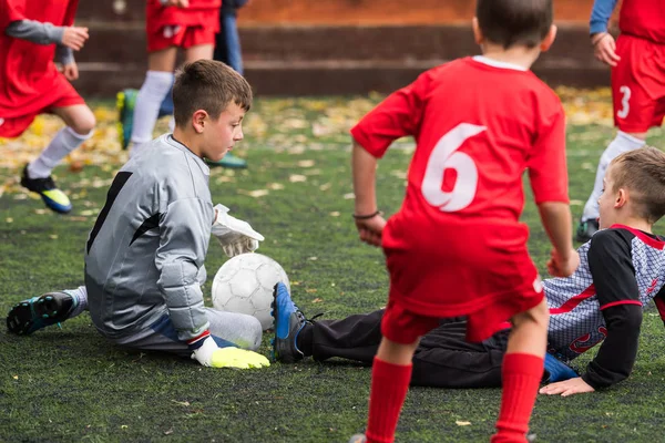 Jungen kicken Fußball auf Sportplatz — Stockfoto