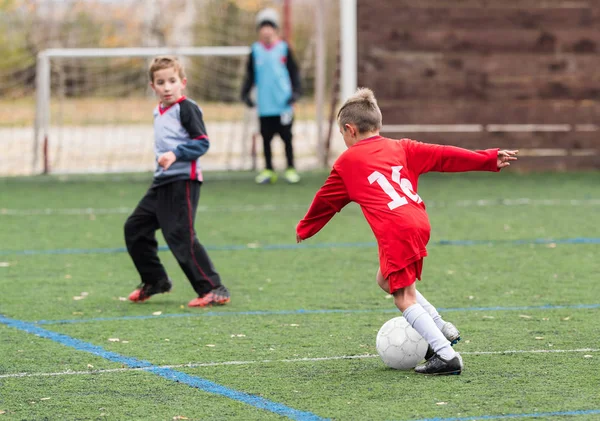 Хлопчик штовхає футбольний м'яч — стокове фото