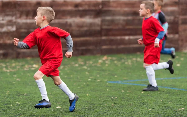 Spor sahasında futbol topu tekmeleme çocuklar — Stok fotoğraf