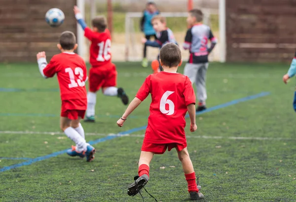 Pojkar sparka fotboll på idrottsplats — Stockfoto