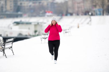 Spor giyim giymek ve kış aylarında kar üzerinde çalışan kız