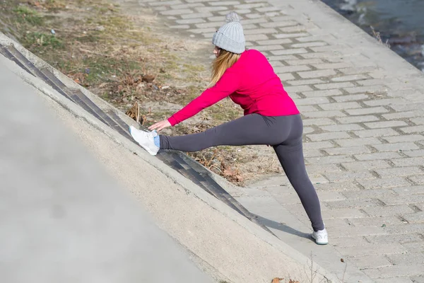 Mädchen trägt Sportbekleidung und macht Dehnübungen bei windigem Wind — Stockfoto