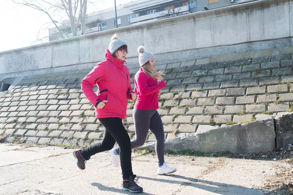 Mutter und Tochter tragen Sportbekleidung und laufen an windigen Tagen — Stockfoto