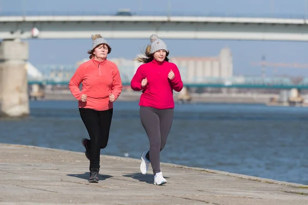 Mutter und Tochter tragen Sportbekleidung und laufen an windigen Tagen — Stockfoto