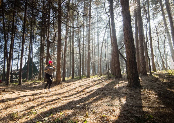 Dívka na sobě sportovní a běží v lese v horském — Stock fotografie