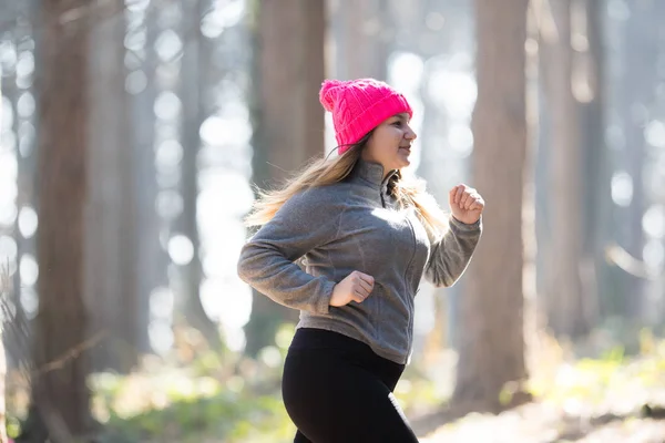スポーツ ウエアを着ていると山で森で実行されている女の子 — ストック写真