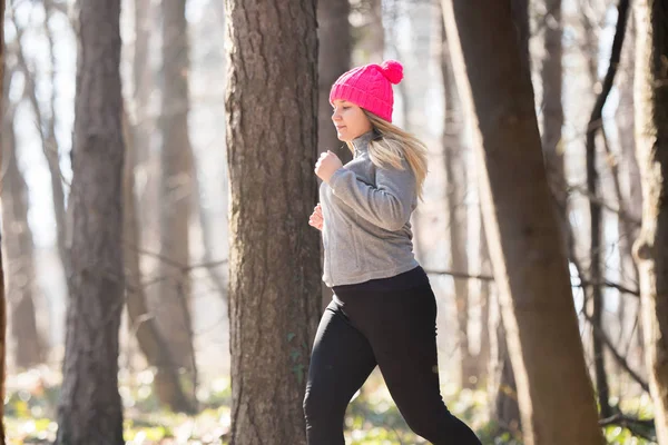Девушка в спортивной одежде и бегает в лесу на горе — стоковое фото