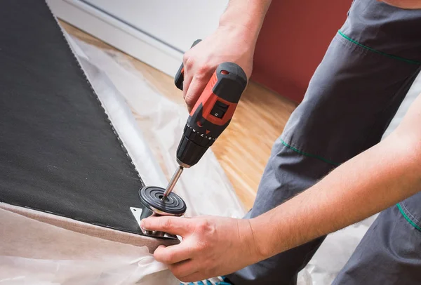 Furniture maker sets bed — Stock Photo, Image