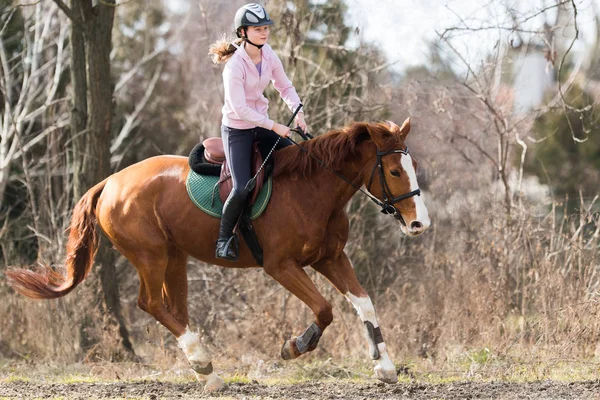 Chica joven montando un caballo — Foto de Stock