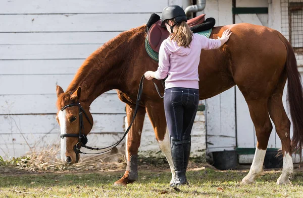 Young girl preparing horse for ride — Stock Photo, Image