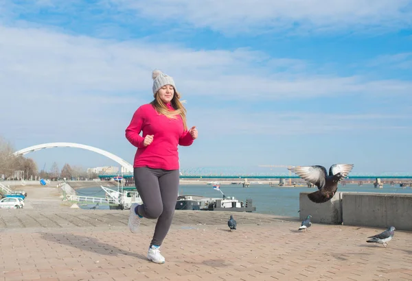 Девушка в спортивной одежде и бегает в ветреный день — стоковое фото
