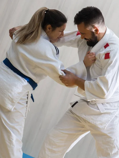 Kvinnan och mannen judo fighters i sporthall — Stockfoto