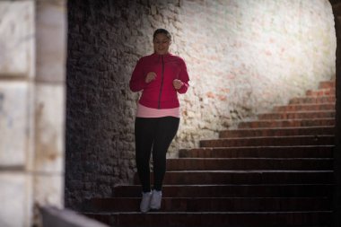Spor giyim giymek ve şehir kale merdiven aşağı koşma kız