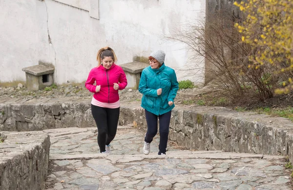 Mutter und Tochter tragen Sportbekleidung und laufen um 12 Uhr die Treppe hoch — Stockfoto