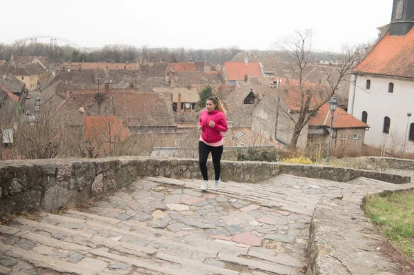 Mädchen trägt Sportbekleidung und rennt die Treppe zur Stadtfestung hinauf — Stockfoto