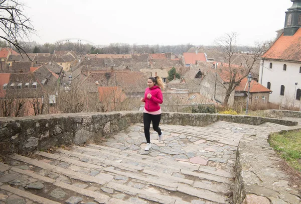 Mädchen trägt Sportbekleidung und rennt die Treppe zur Stadtfestung hinauf — Stockfoto