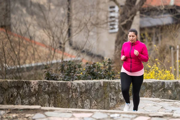 Dívka na sobě sportovní a běžela nahoru na městské pevnosti — Stock fotografie