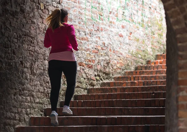 Mädchen trägt Sportbekleidung und rennt die Treppe zur Stadtfestung hinauf — Stockfoto